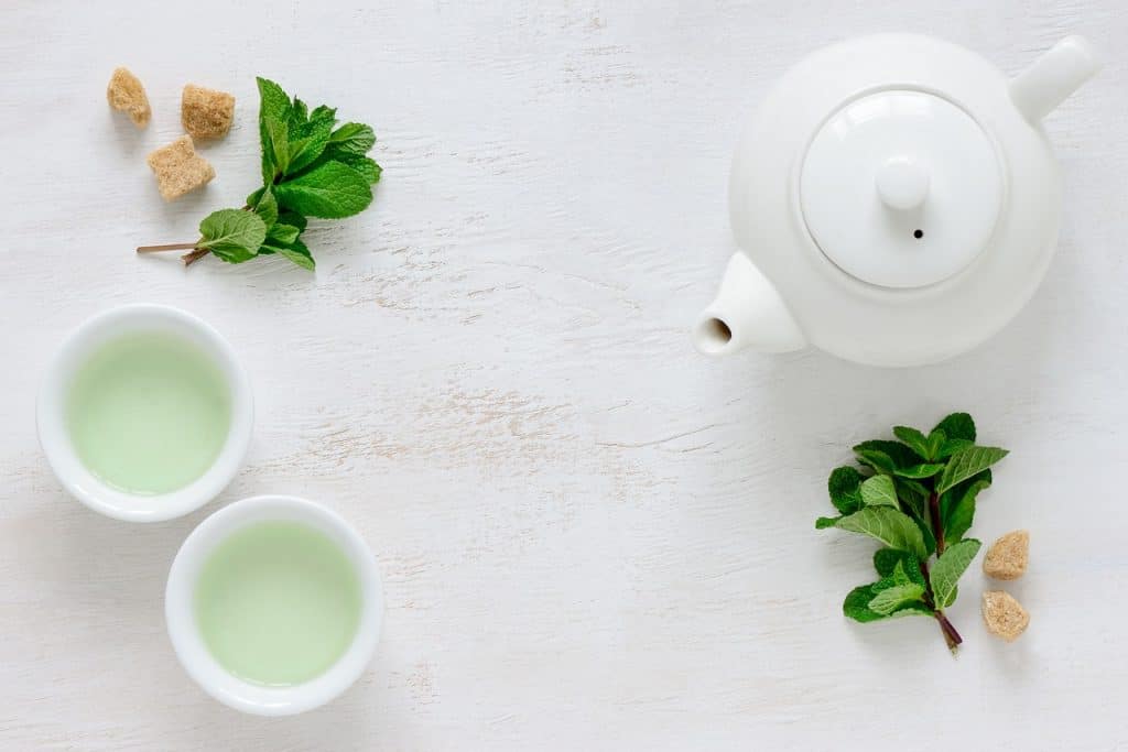 a white kettle and 2 cups of detoxifying green tea
