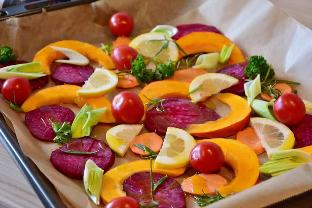 a mix of beets, lemons and tomatoes on a baking sheet