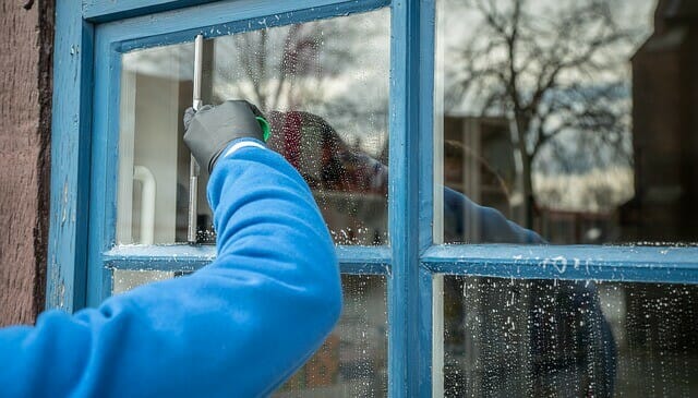man washing windows with a natural cleaner